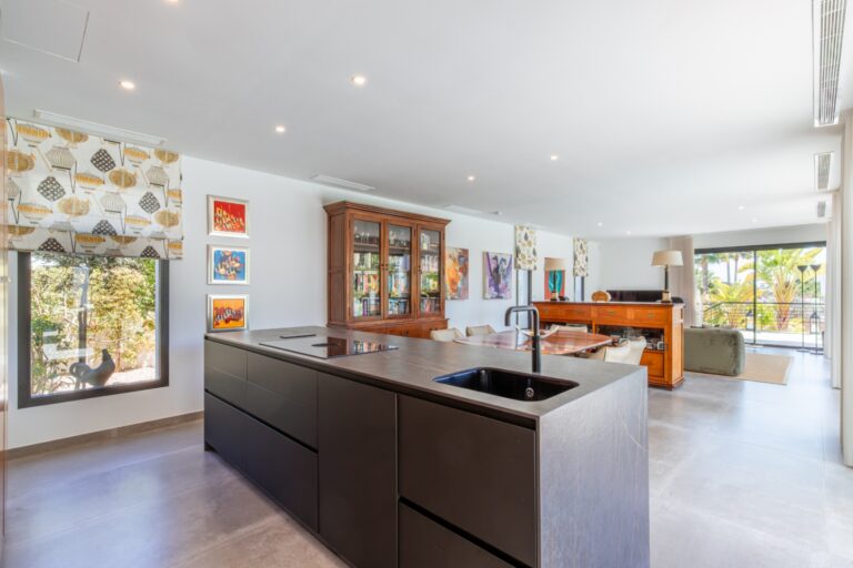 Open-plan kitchen and living area inside a modern villa in Solpark, Moraira with DEKTON island, dining area, large windows and pool terrace access