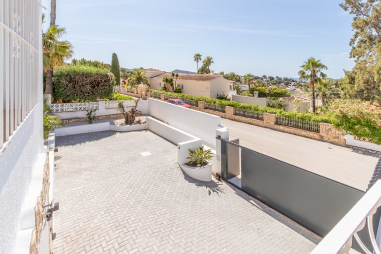 Open terrace at a renovated Mediterranean villa in Moraira with outdoor seating, open views, surrounding homes and spacious paved outdoor area