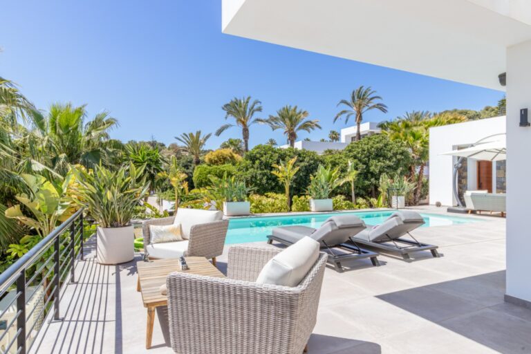 Pool terrace at a modern villa in Solpark, Moraira with heated swimming pool, outdoor seating, sun loungers and landscaped garden surroundings