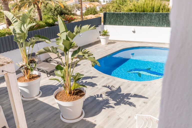 Pool terrace at a renovated Mediterranean villa in Moraira with private swimming pool, potted plants, sun terrace and surrounding greenery