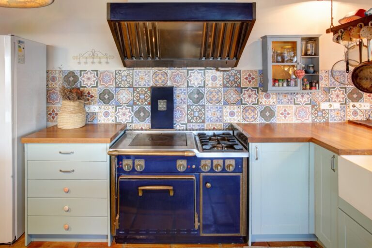 Professional Molteni gas range inside a rustic Mediterranean estate near Moraira with patterned tile splashback, extractor hood and traditional kitchen details