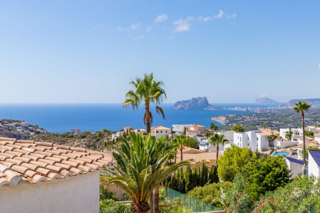 Sea views from a luxury smart home villa near Moraira with Mediterranean coastline, palm trees, surrounding villas and Peñón de Ifach in the distance