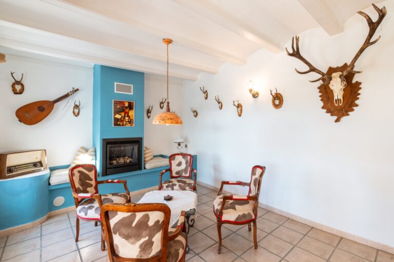 Sitting area inside a renovated finca near Teulada and Moraira with fireplace, traditional seating, white beamed ceiling and character details