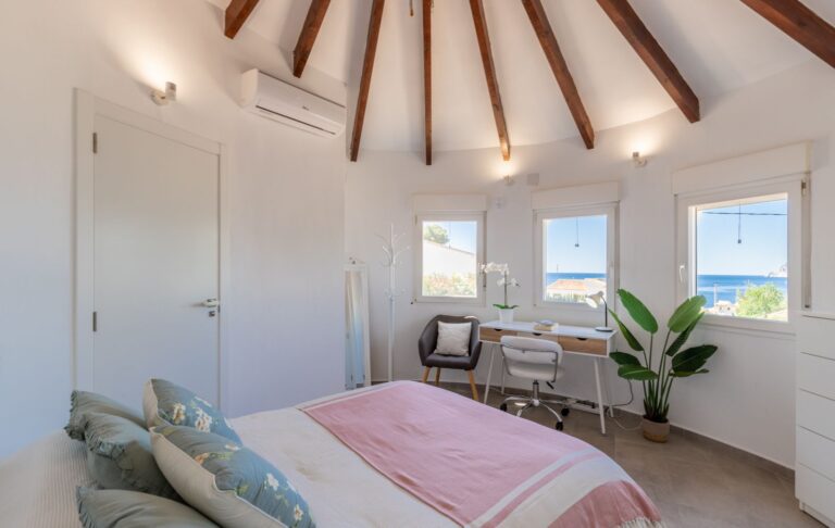 Tower room inside a renovated villa near Cala Baladrar in Benissa Costa with sea views, double bed, desk area, exposed beams and natural light