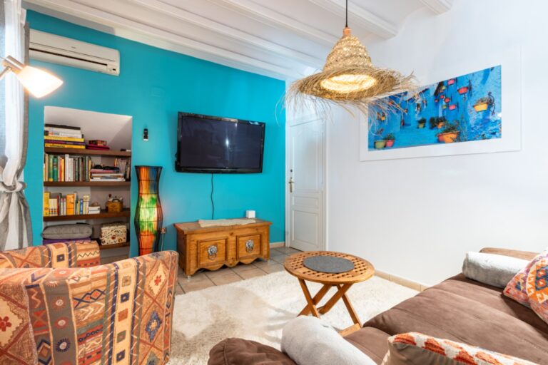 TV lounge inside a renovated finca near Teulada and Moraira with blue feature wall, sofa seating, wall-mounted TV and relaxed interior setting