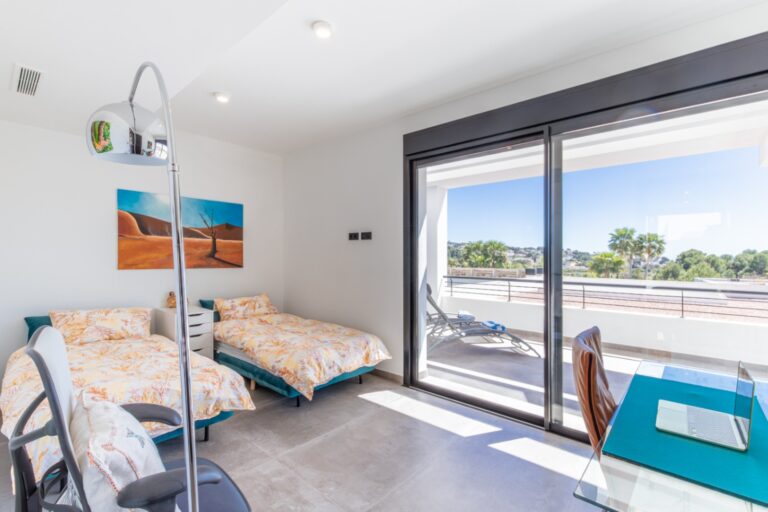Twin bedroom inside a modern villa in Solpark, Moraira with private terrace access, two single beds, large sliding doors and bright contemporary interior