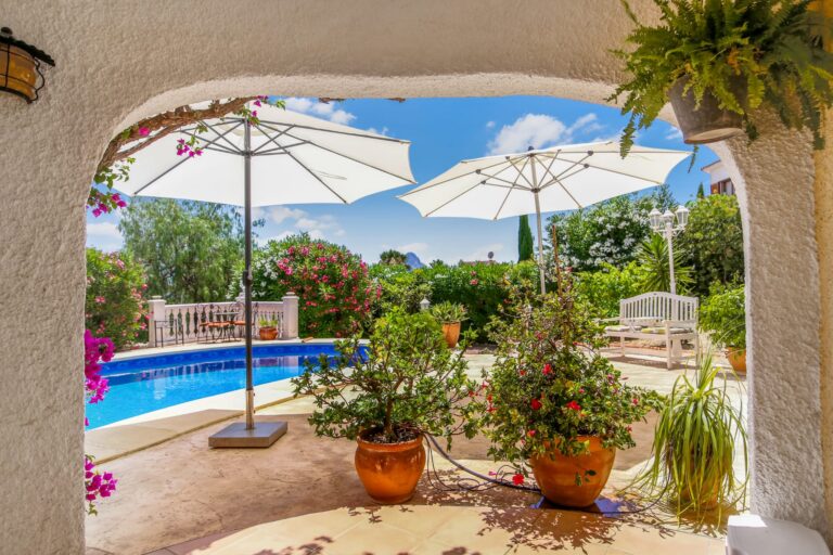 Covered terrace overlooking the pool and garden at a villa for sale in Calpe