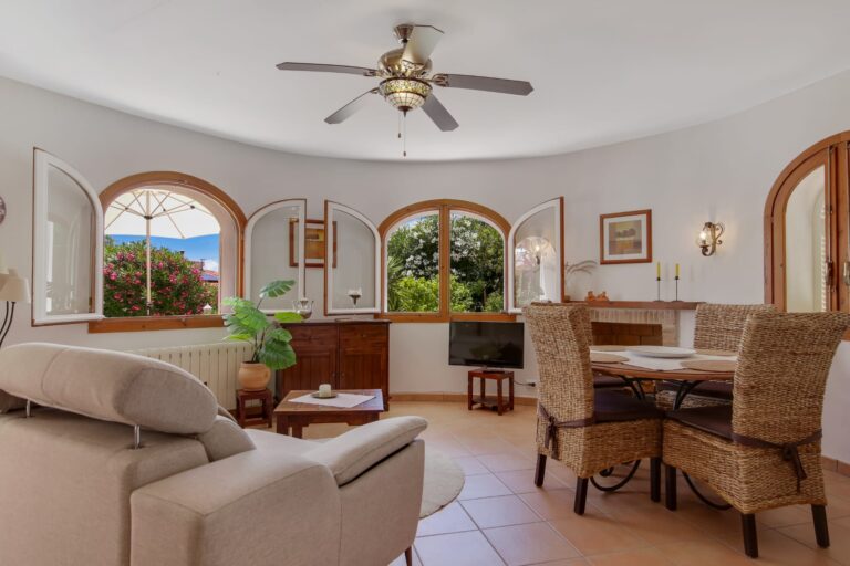 Open living and dining area with arched windows in a sea view villa for sale in Calpe