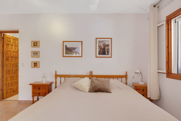 Second double bedroom with window and ceiling fan in a villa for sale in Calpe