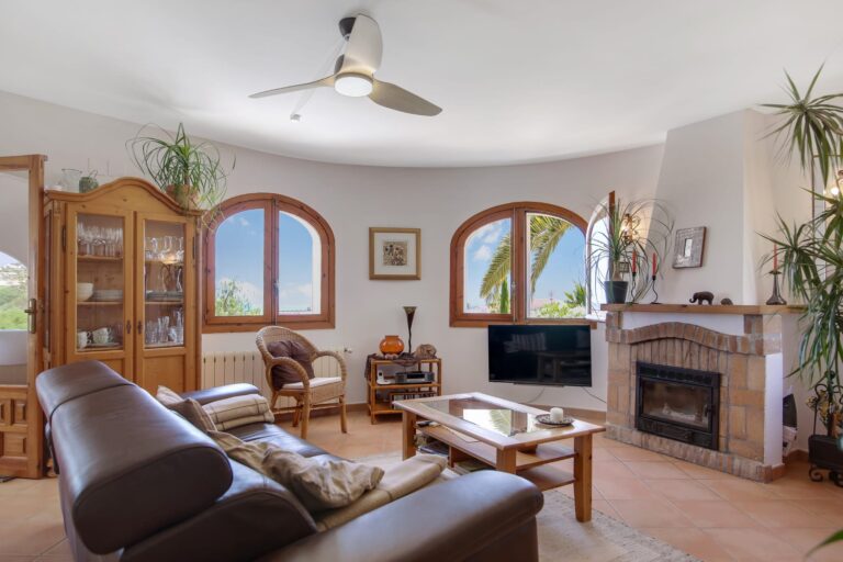 Spacious living room with fireplace and arched windows in a Mediterranean villa in Calpe